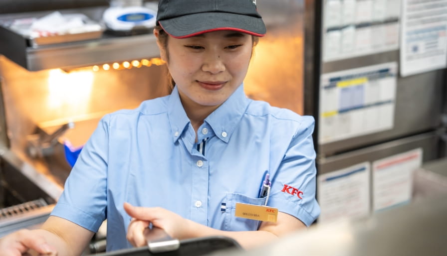 フライヤーで調理を行う店舗スタッフ